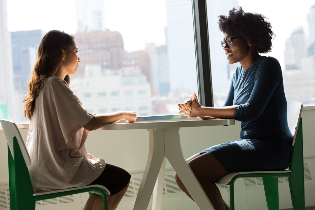 This is a photo of two women talking and smiling